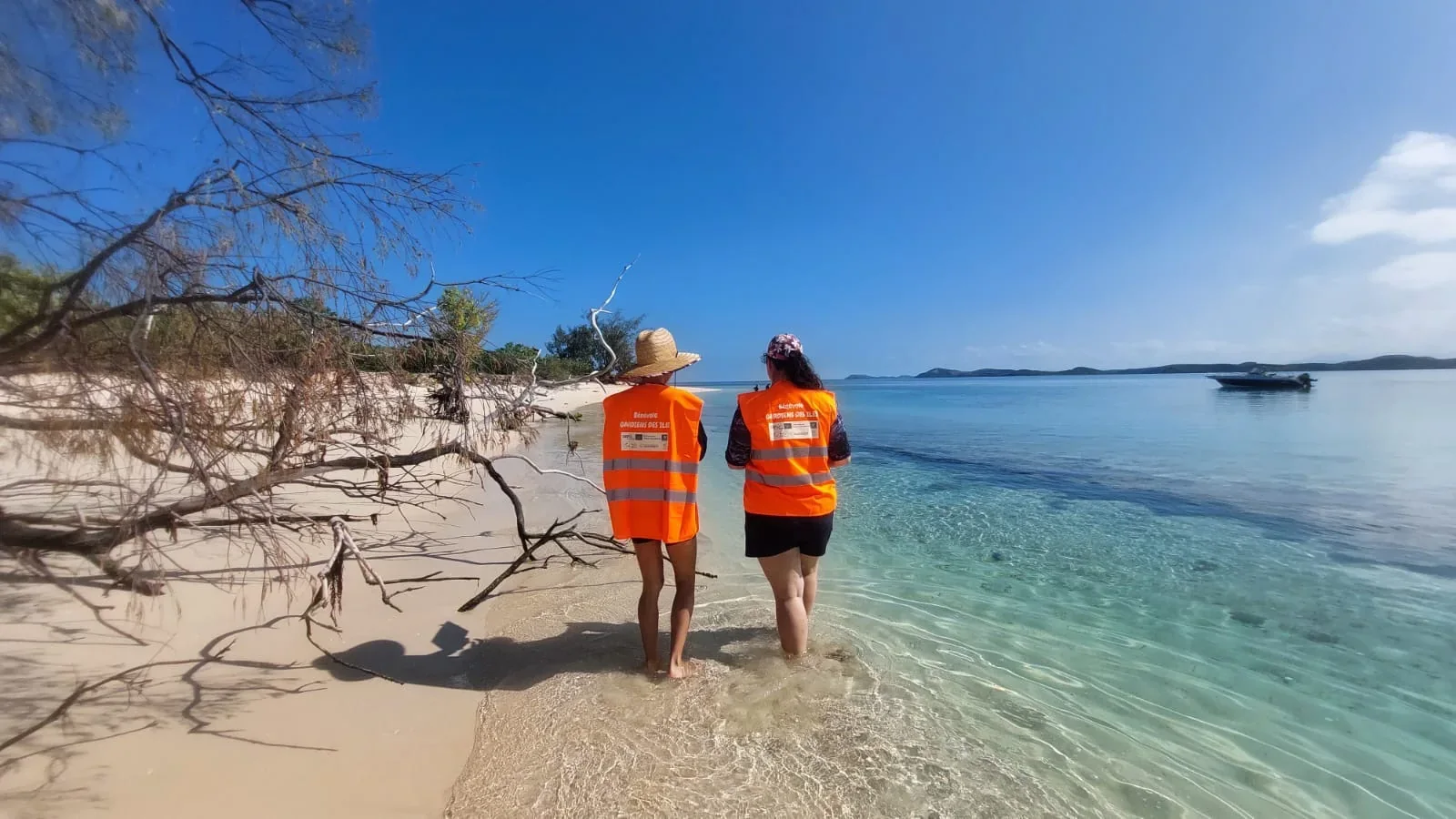 Deux bénévoles des Gardiens des îles sur une plage au bord du lagon